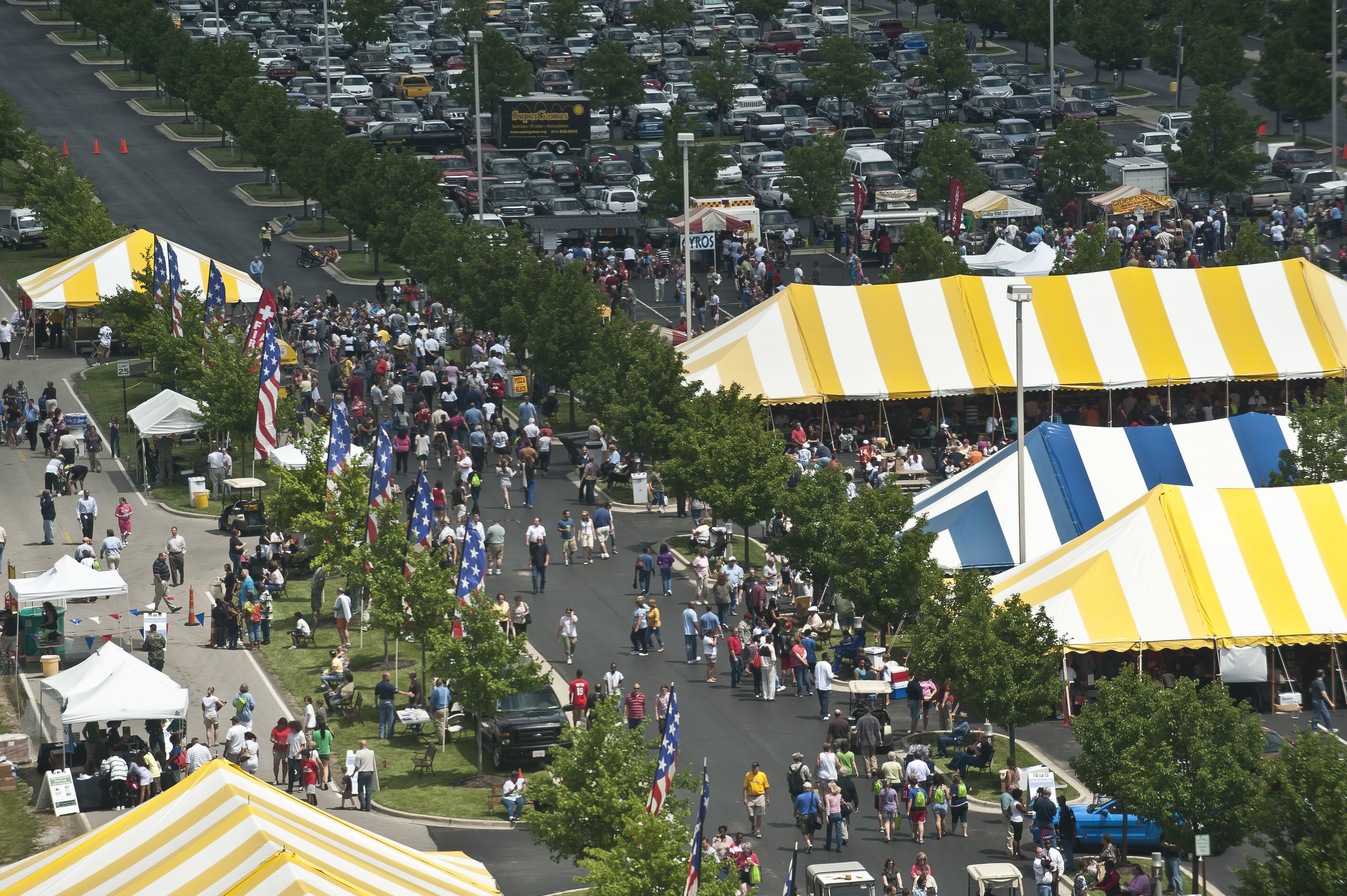 overhead image of people at a festival with large tents overhead image of people at a festival with large tents